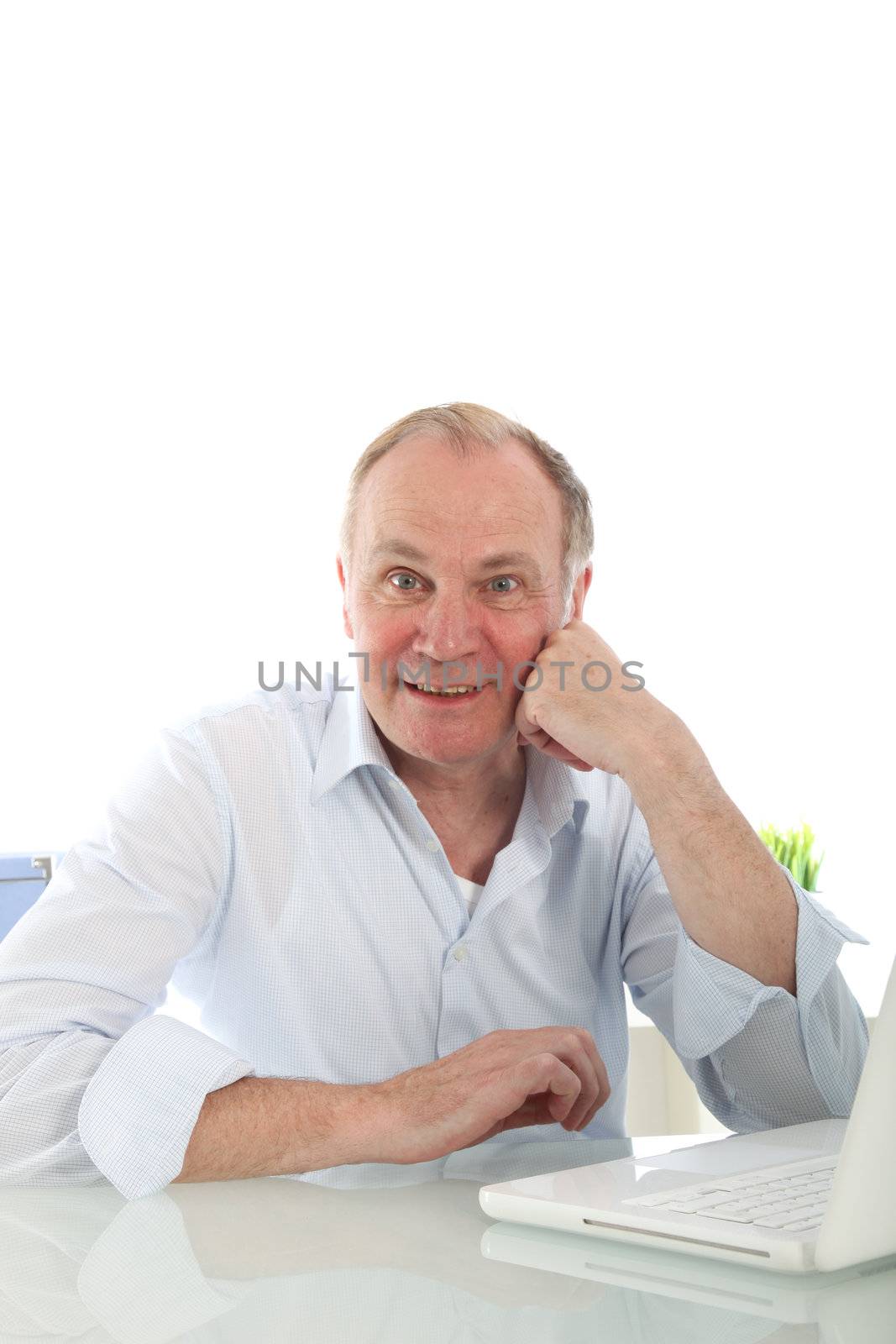 Interested enthusiastic businessman leaning on his desk looking at he camera with an alert expression 