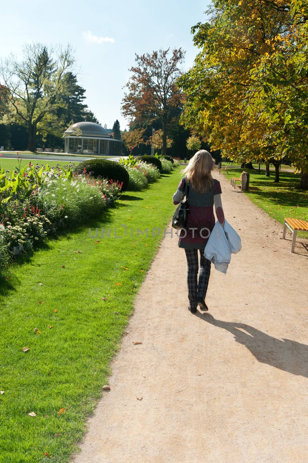 The girl goes down the avenue in a park near fantanov