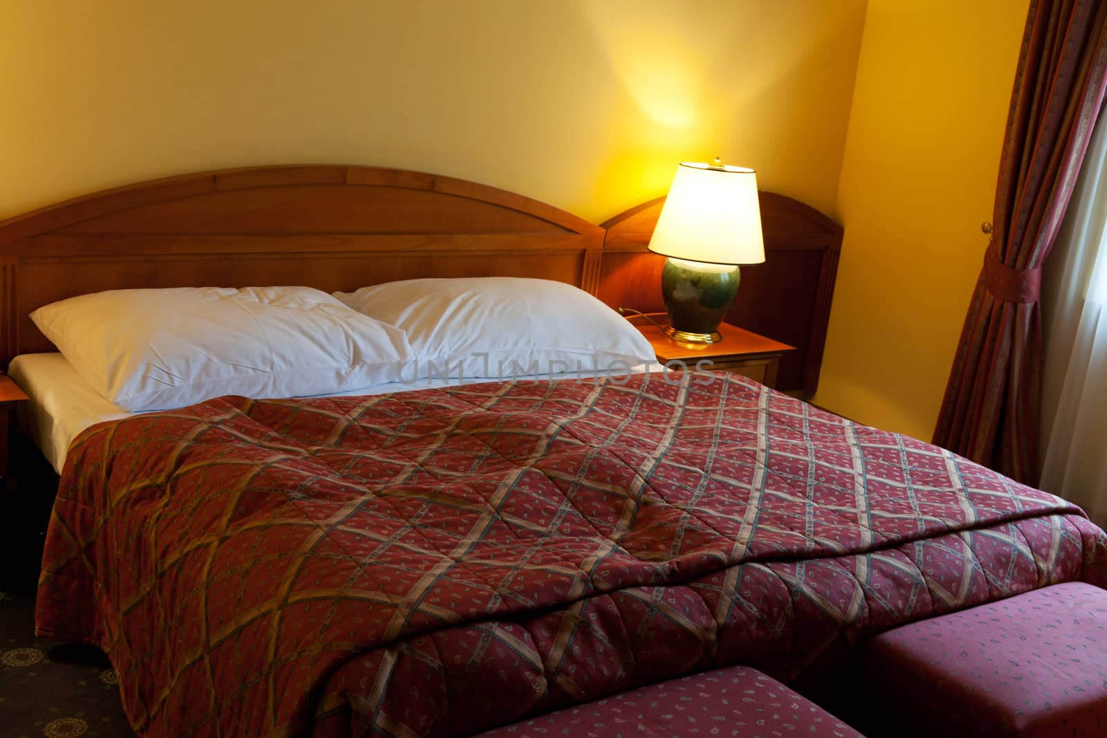 dressed with a red coverlet bed in hotel room