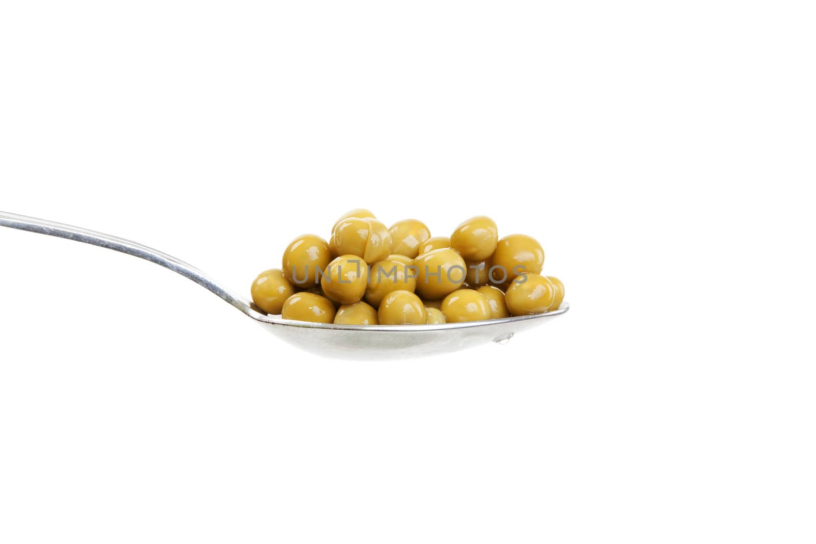 Spoon with green peas on a white background