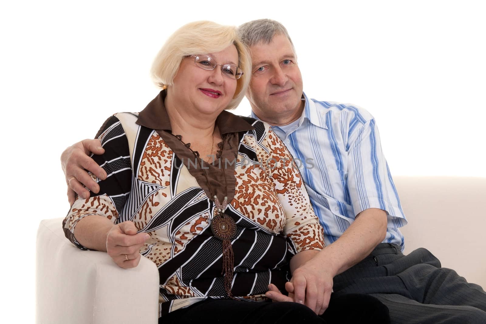 Mature couple sitting on a sofa on a white background