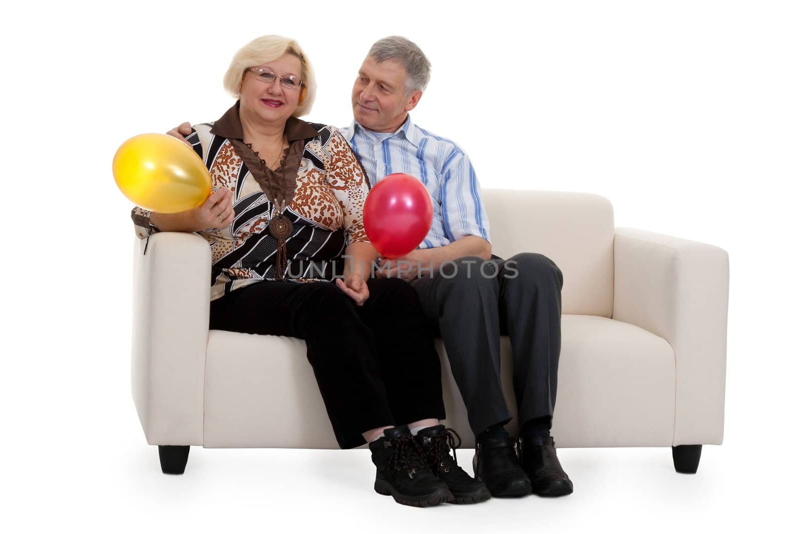 Mature couple sitting on a sofa on a white background