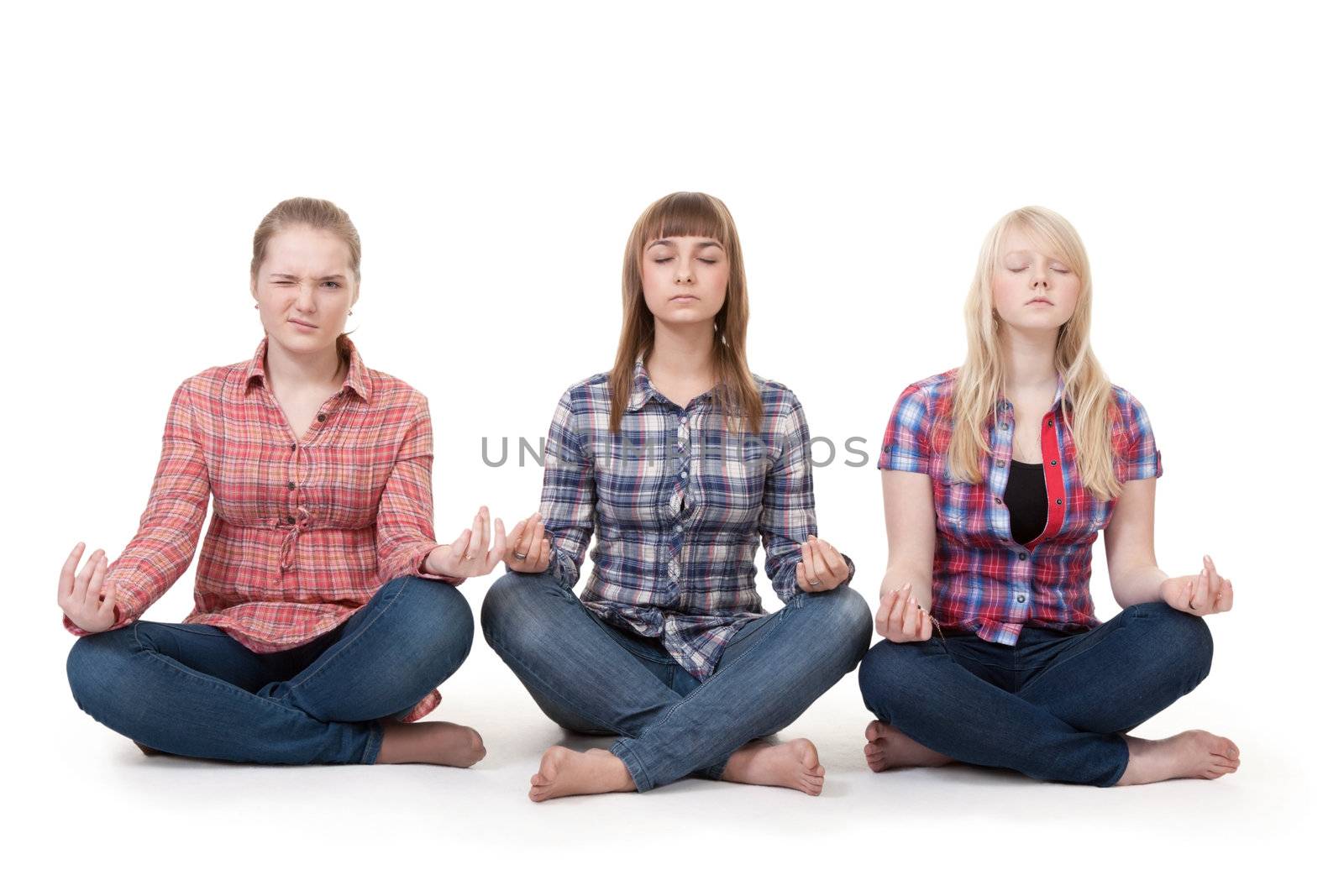 Three girls sitting in lotus posture on a white background