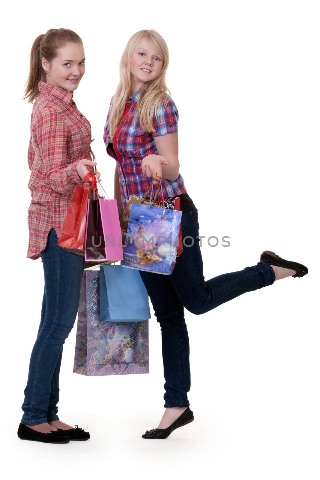 Two young beautiful girls on shopping on a white background