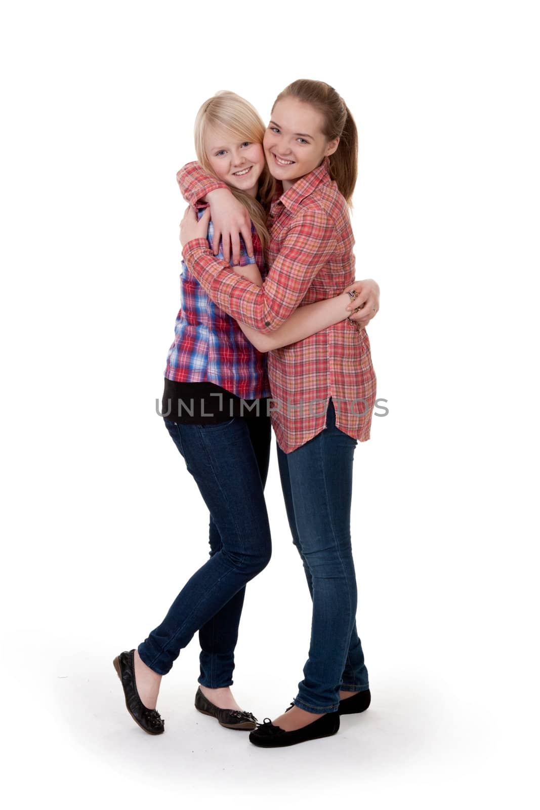 two girlfriends in checkered shirts hug on white background
