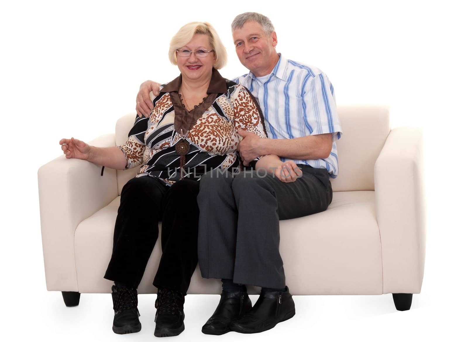 Mature couple sitting on a sofa on a white background
