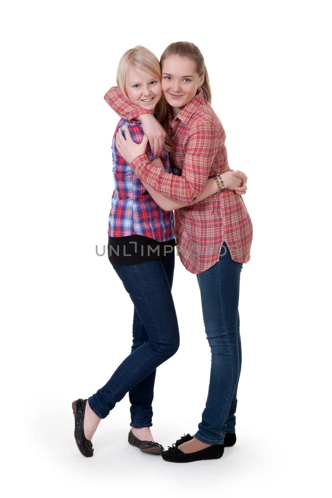 two girlfriends in checkered shirts hug on white background