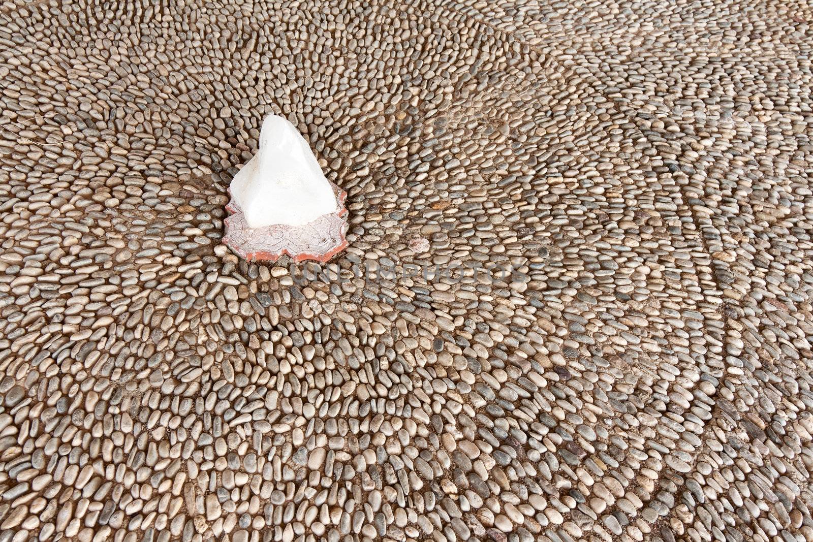 pavement of small stones and a large white crystal