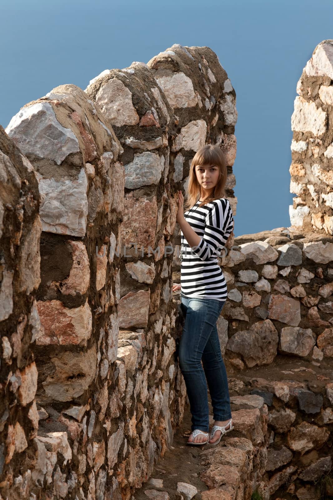 Beautiful girl on the wall of an old fortress