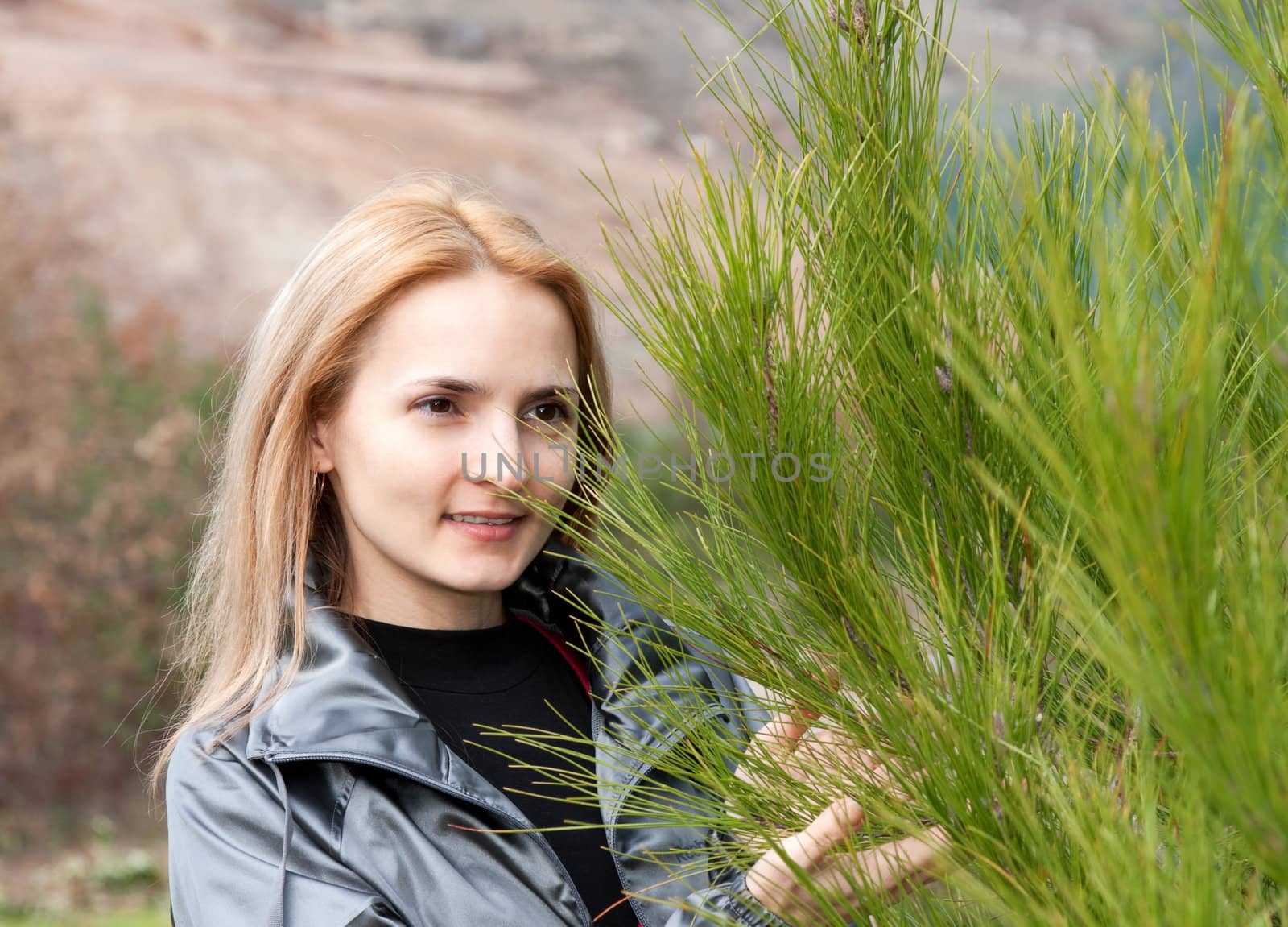 Portrait of a beautiful girl with a pine tree
