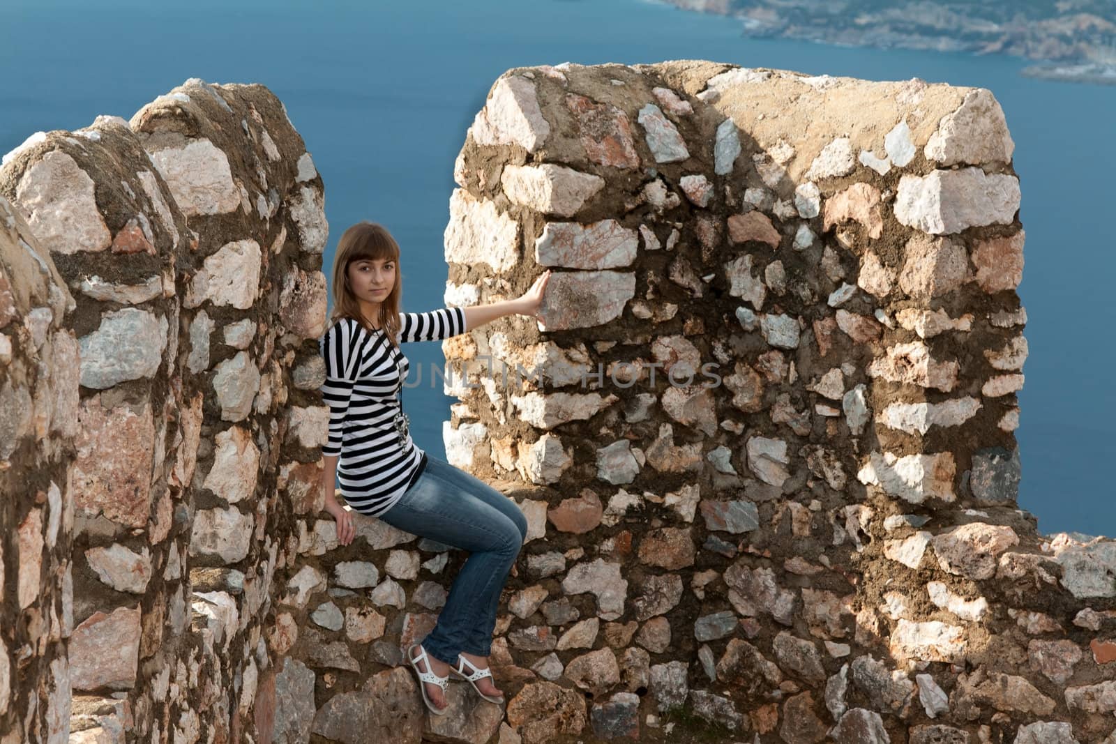 Beautiful girl on the wall of an old fortress