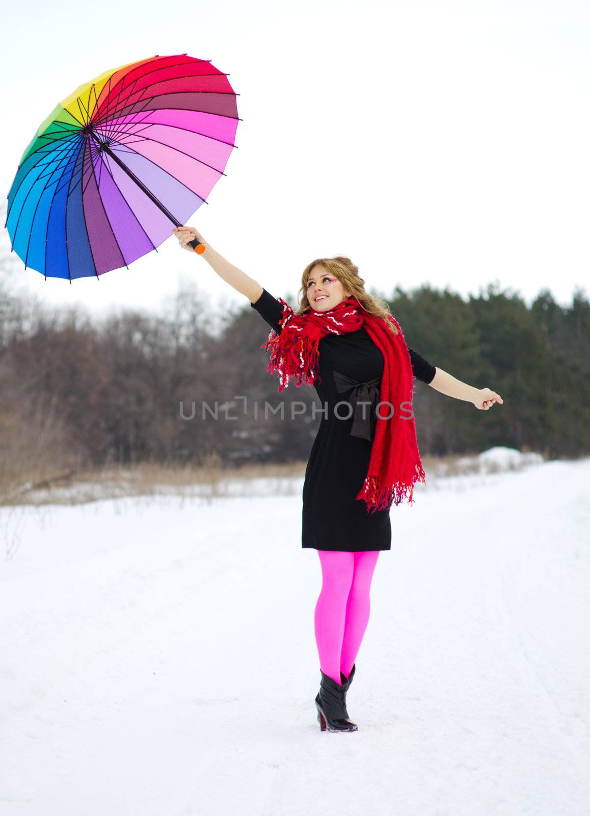 Young woman with multicolor umbrella at forest