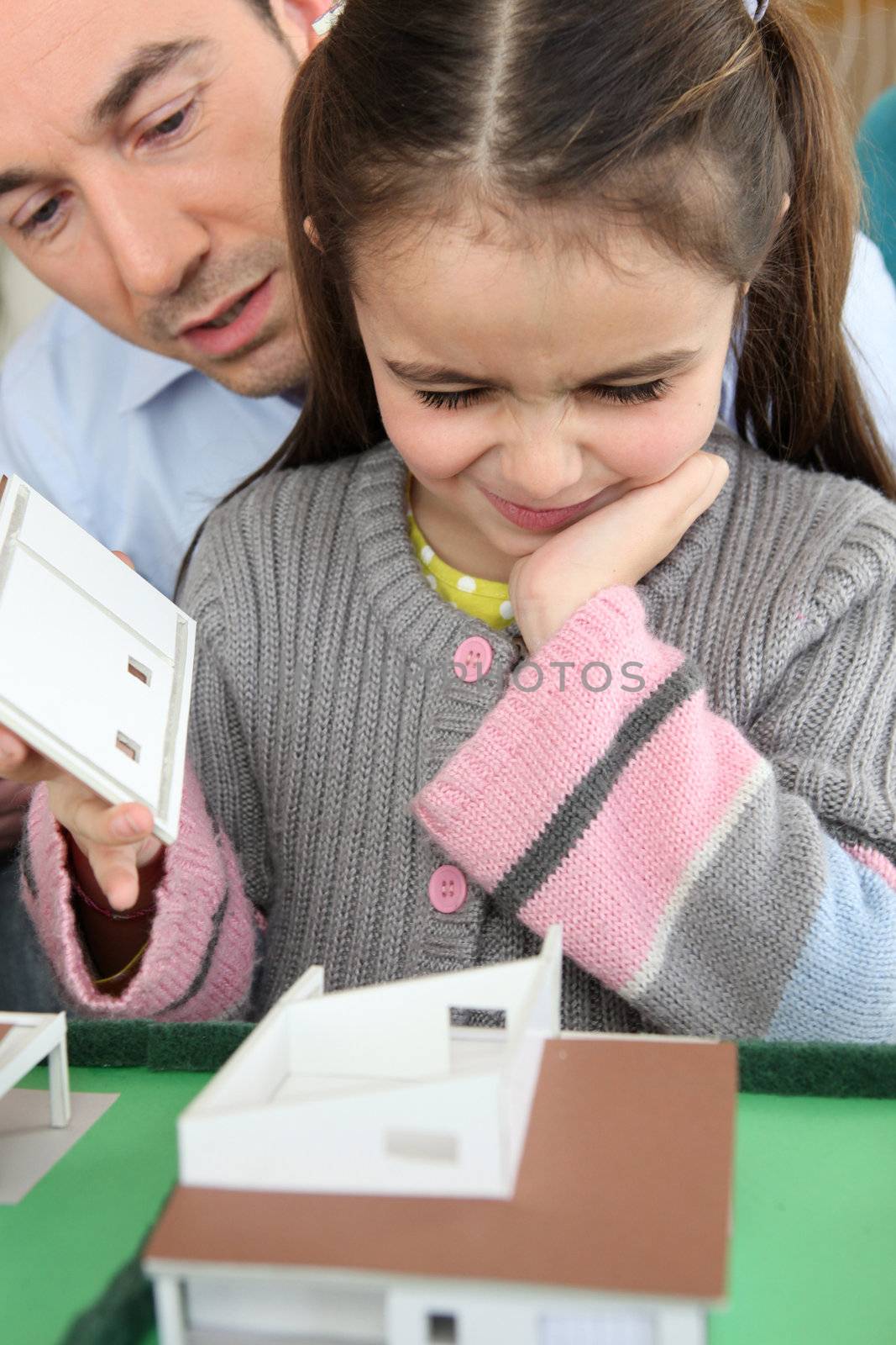 Father and daughter looking at a house model