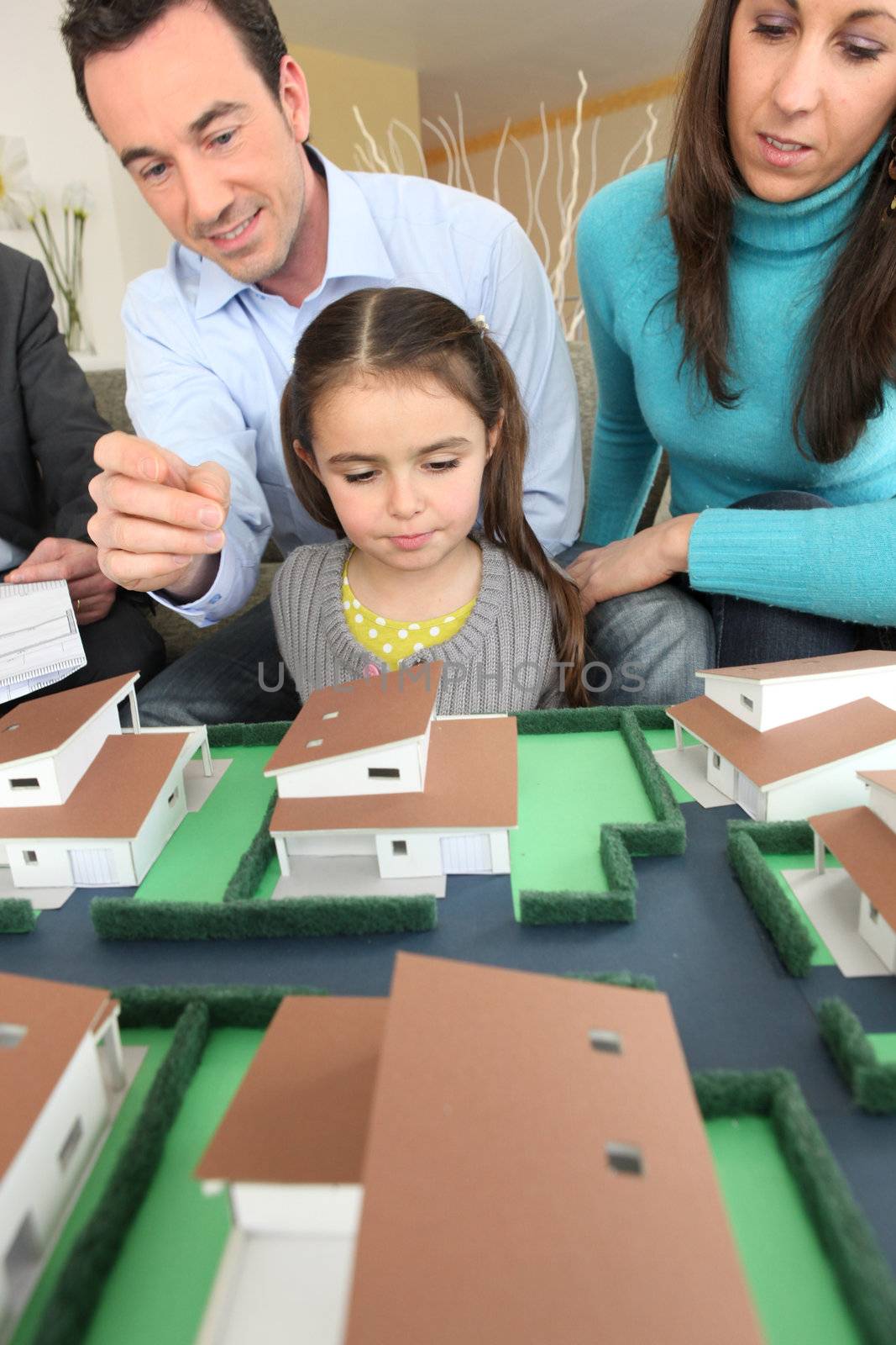 Young family looking at model housing by phovoir