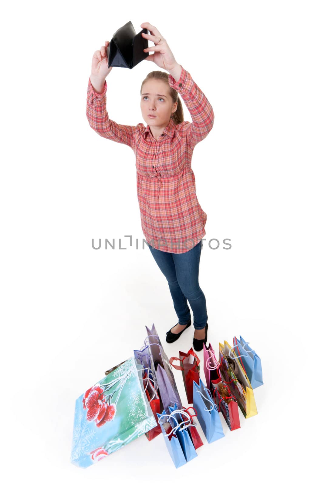 girl looks into an empty wallet next to the packages from the store