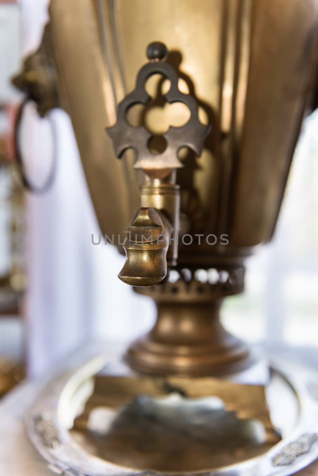 Spout of old russian bronze tea samovar. Selective focus on the front.