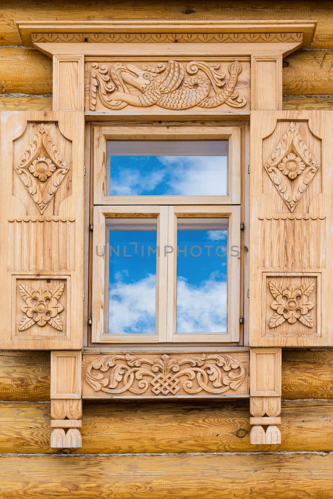 Wooden decorated window in log house, Russian traditional architecture.