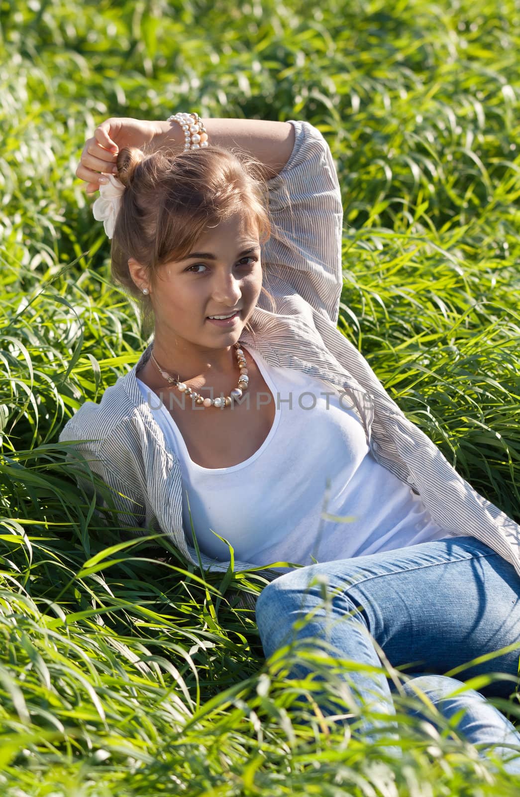 portrait of a beautiful girl in the green grass