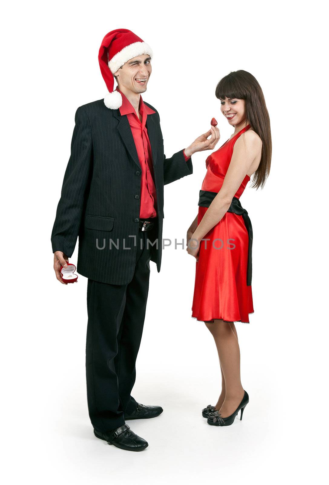 Man in Santa hat brings strawberries hiding behind a ring