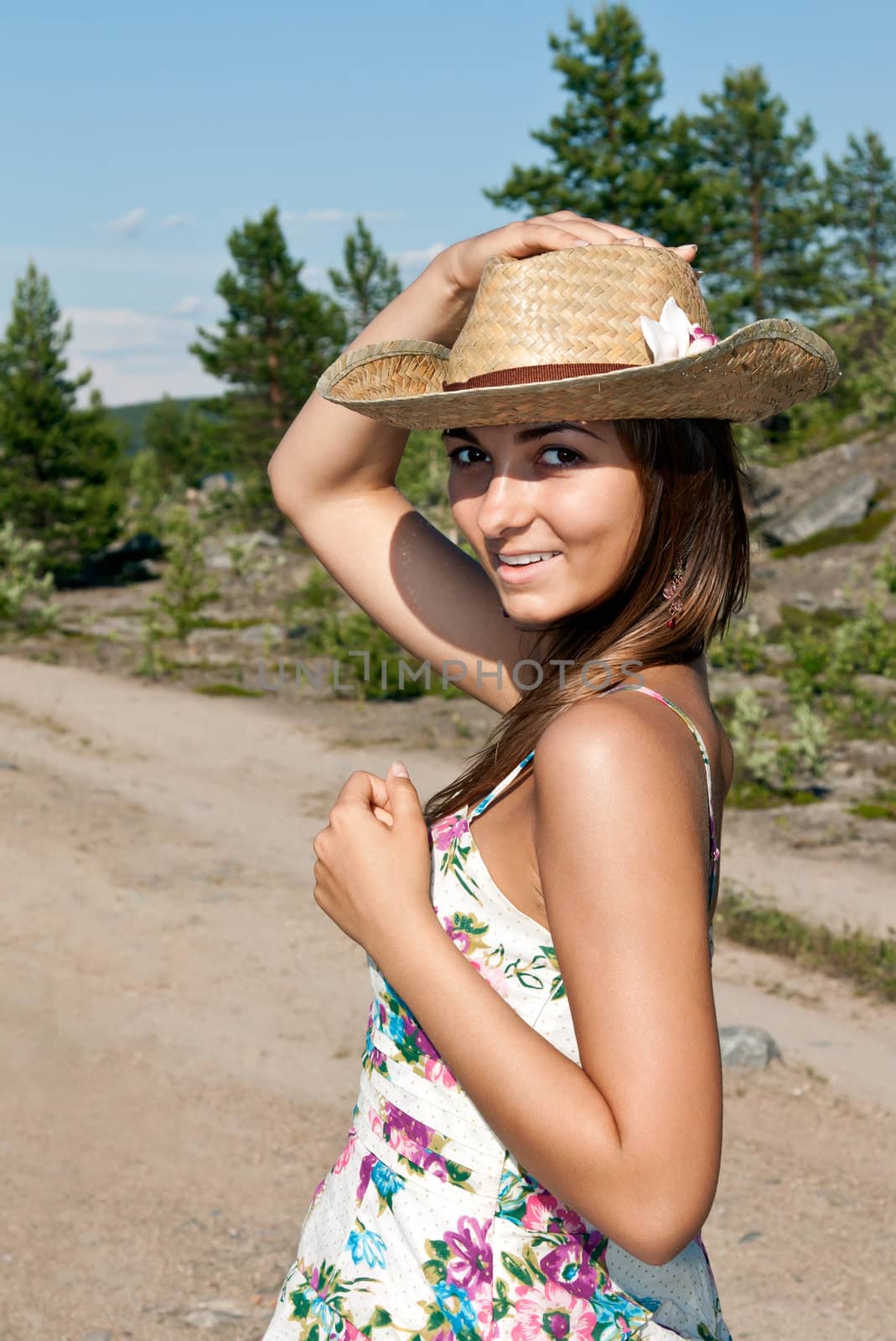 girl in a straw hat on a forest road
