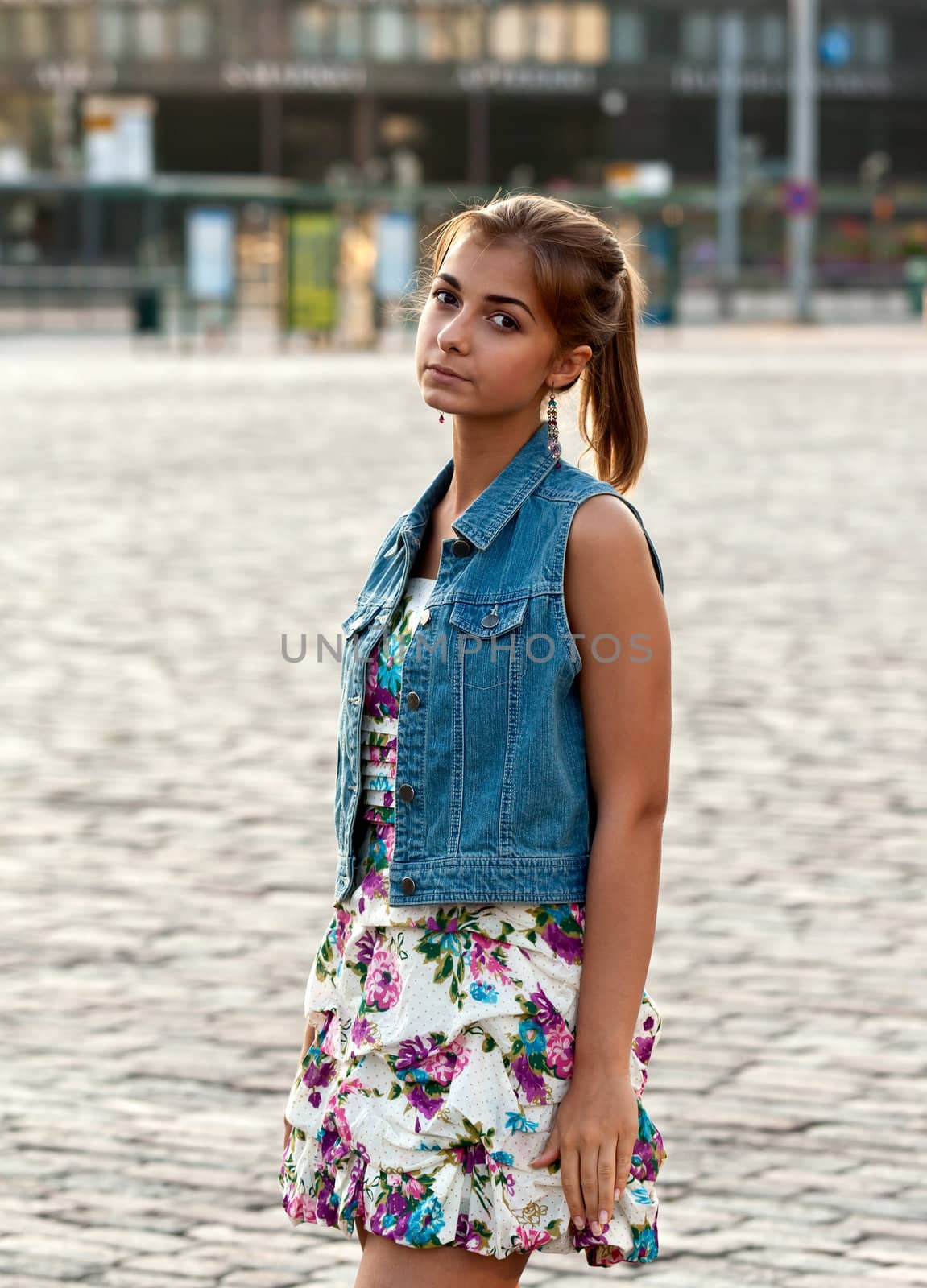 portrait of beautiful girl in the denim vest in the square