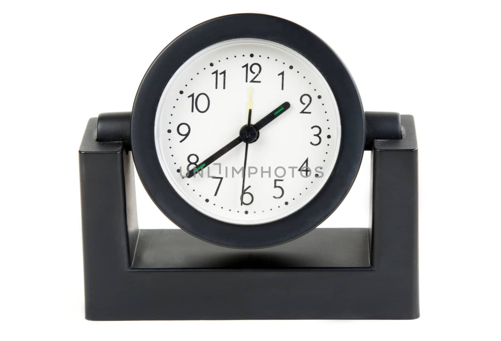 Desktops mechanical clock in a black plastic casing with a white background