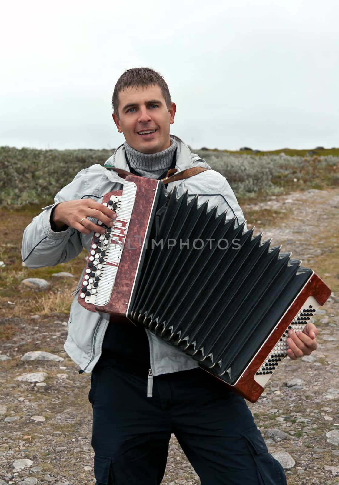 man with an accordion in the background of the Barents Sea