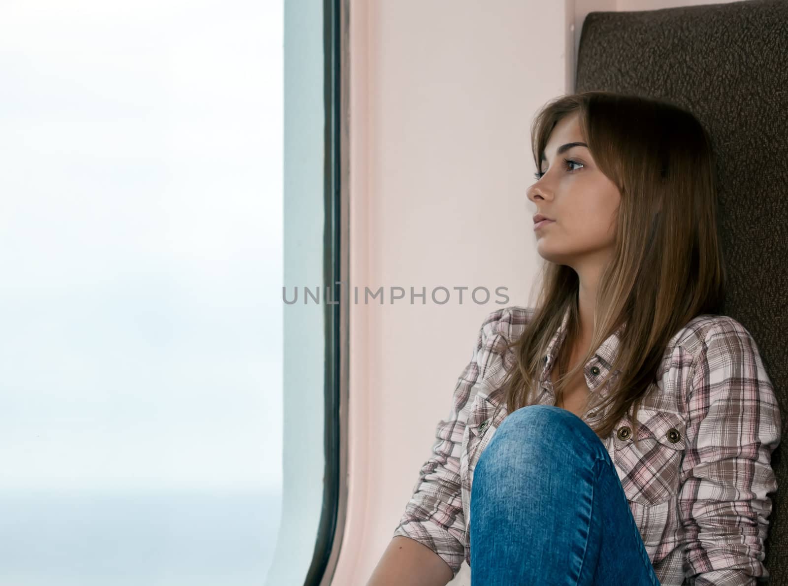 pensive woman sitting by the window