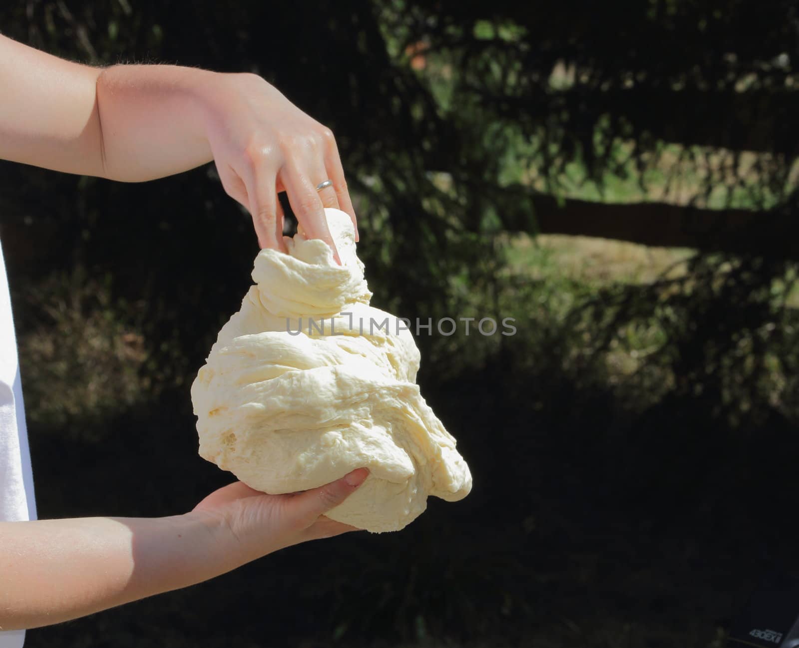 two hands kneading dough for a cake