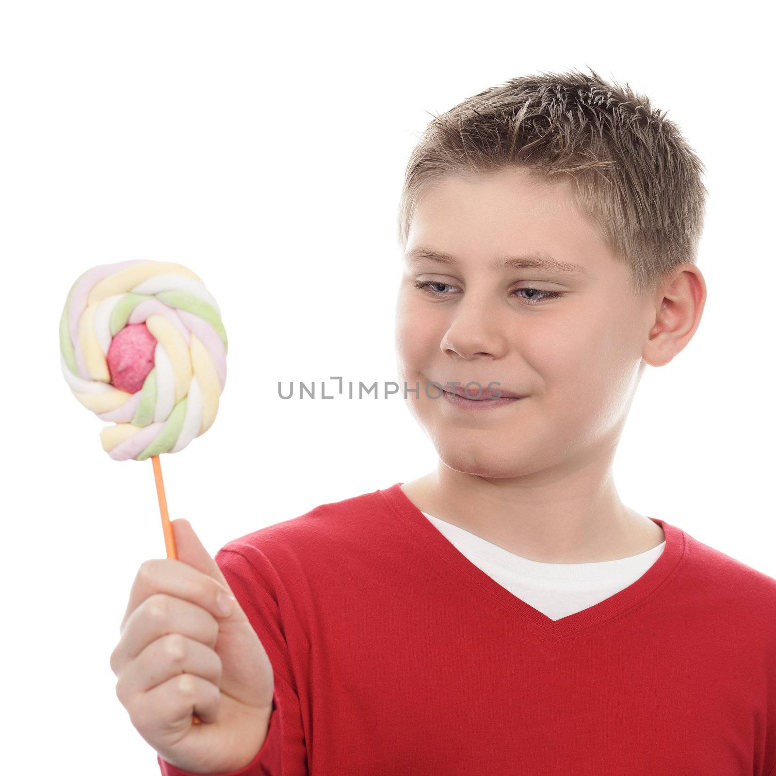 Portrait of joyful boy looking at lollipop