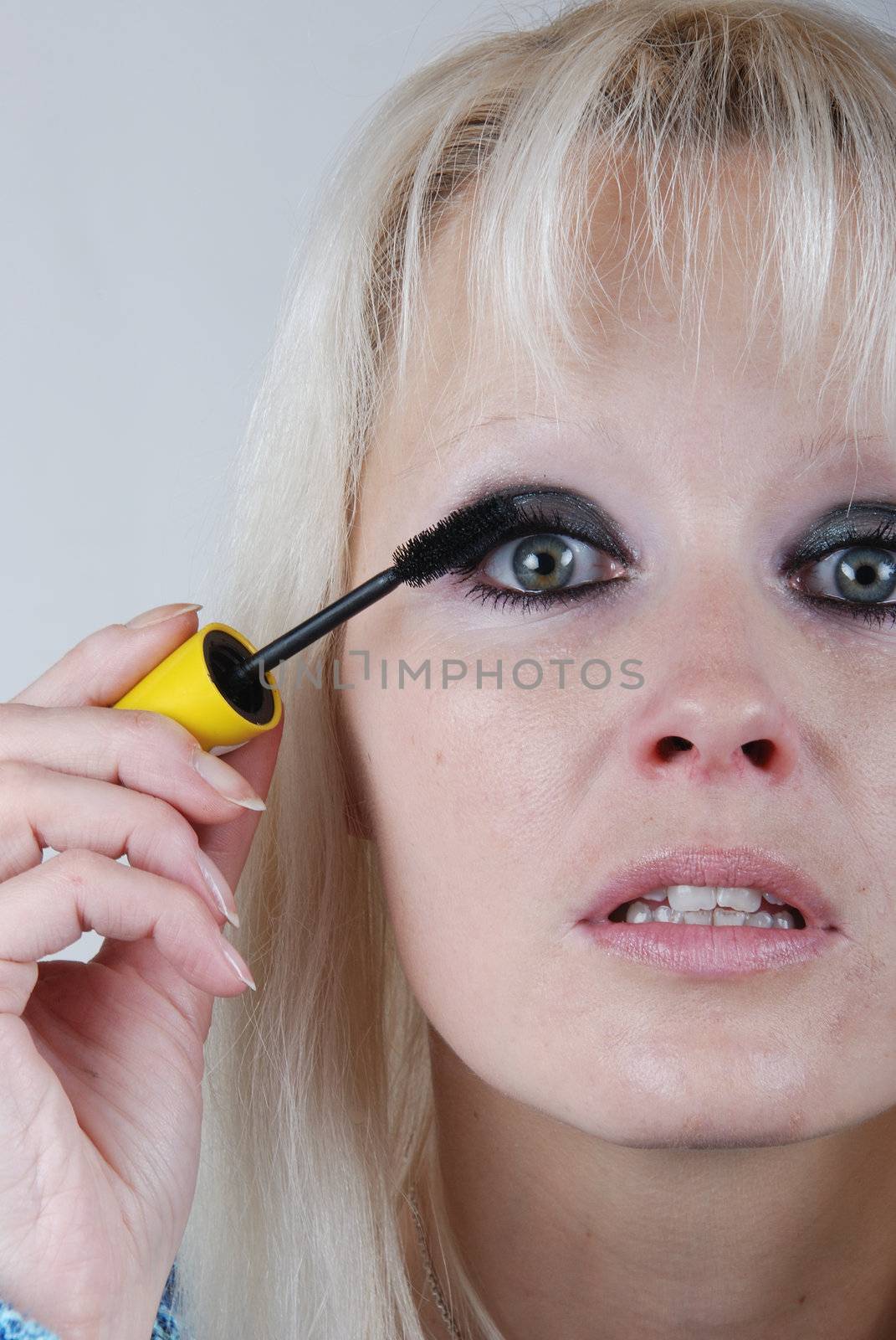 Woman applying makeup on her face 