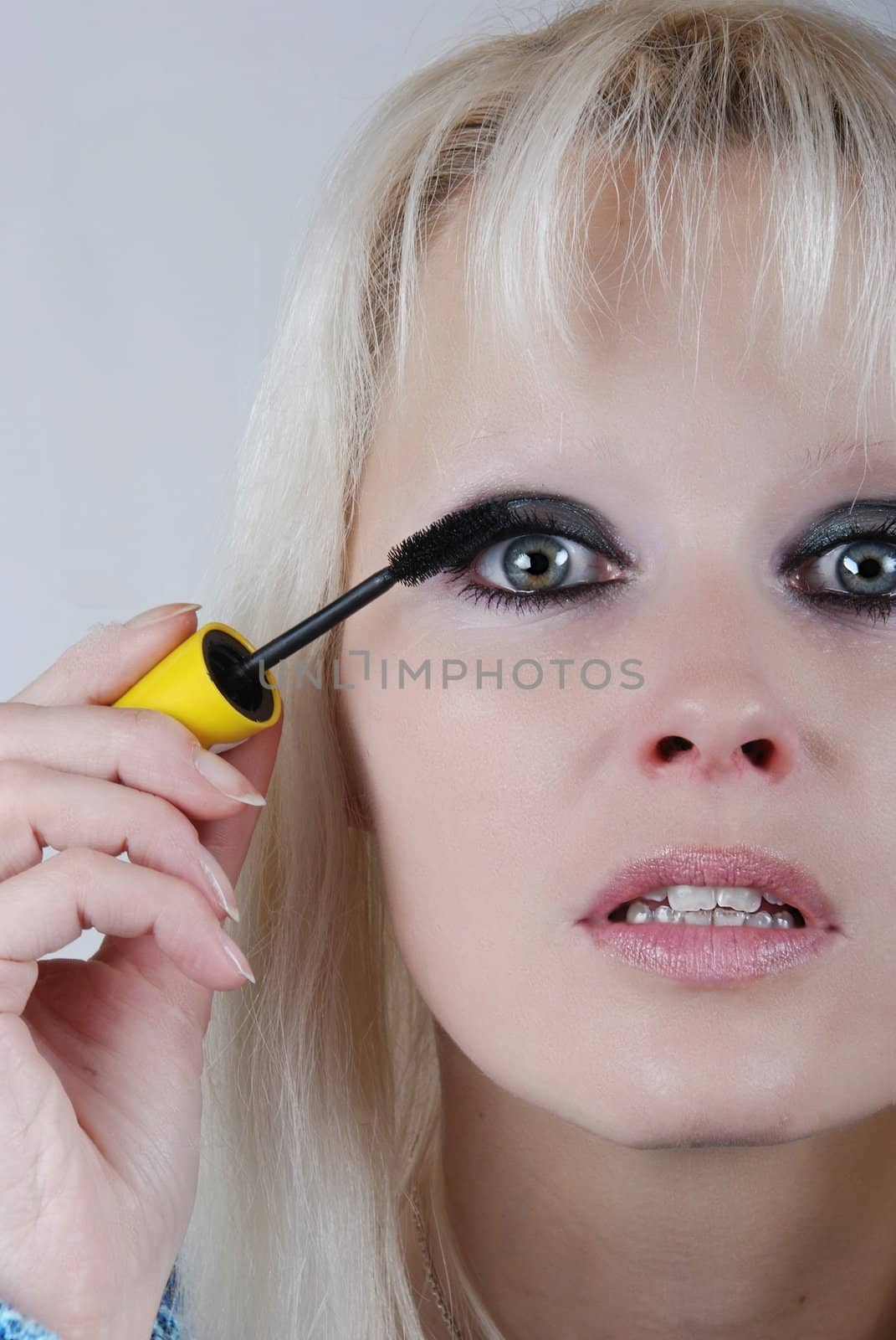 Woman applying makeup on her face 