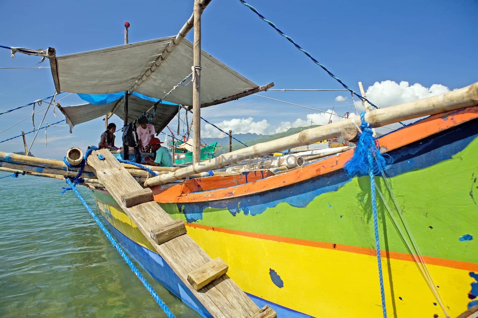 Filipino family living on their fishing boat in Subic Town, Philippine Islands. These boats are used for fishing and for local transportation. The boats are called outriggers, canoes, pump boat and bangka.