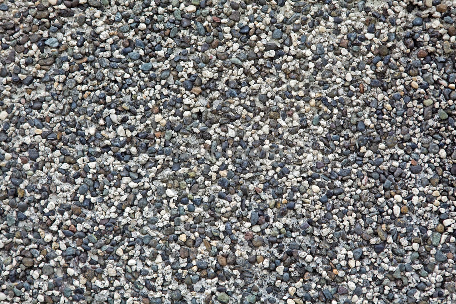 Abstract background of white, black, gray, grey, blue and brown small pebbles.