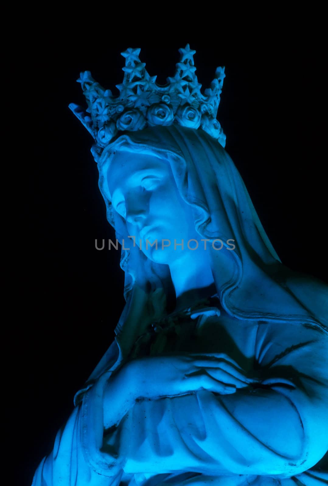Christian statue of the Madonna in blue light.