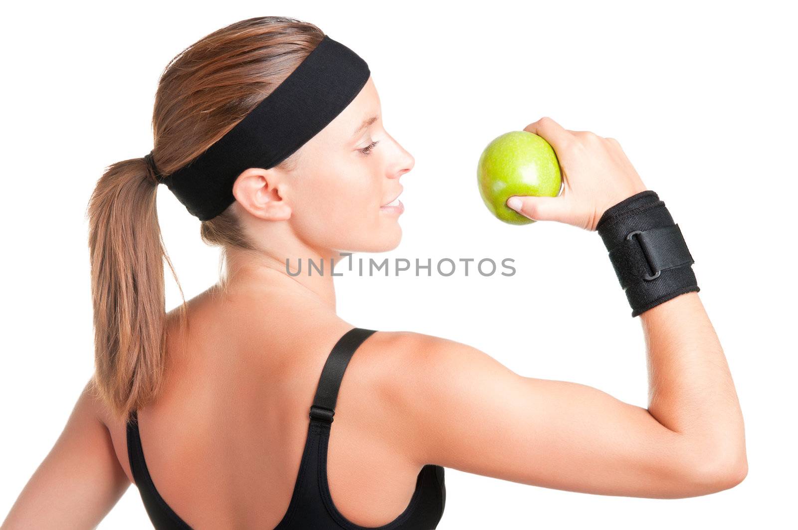 Woman about to eat a green apple after her workout at the gym