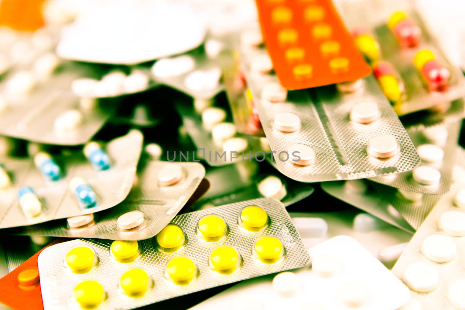 Pills of many shapes and colors grouped together.