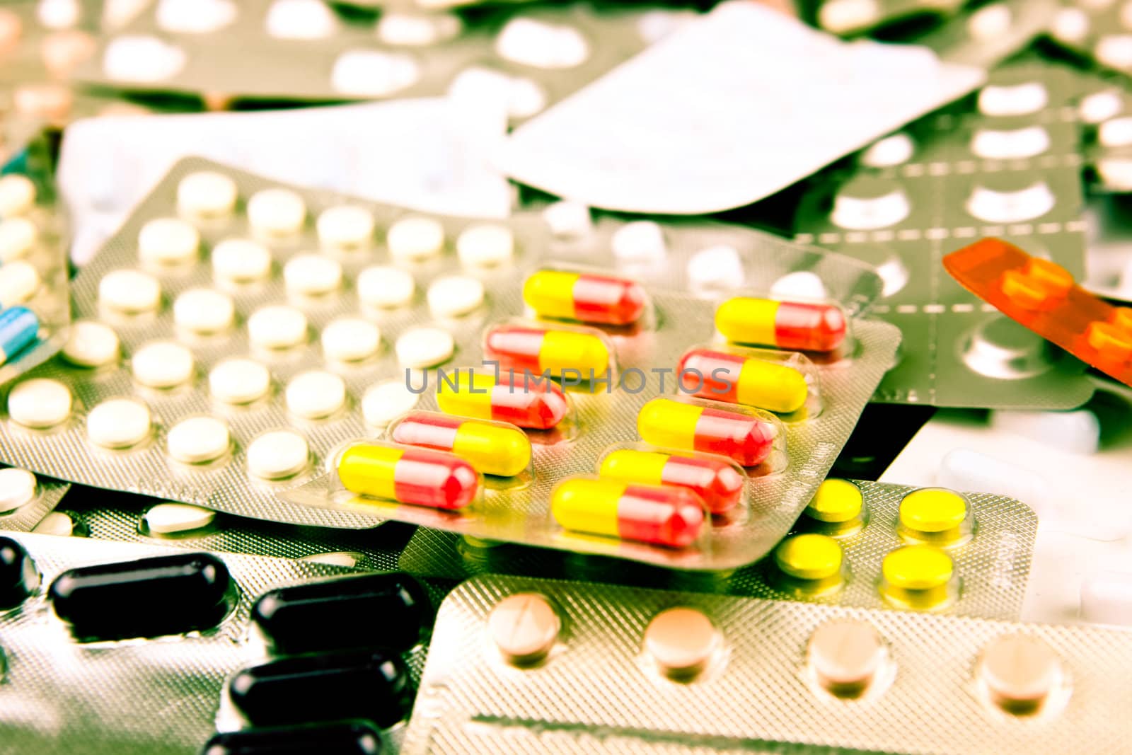 Pills of many shapes and colors grouped together.