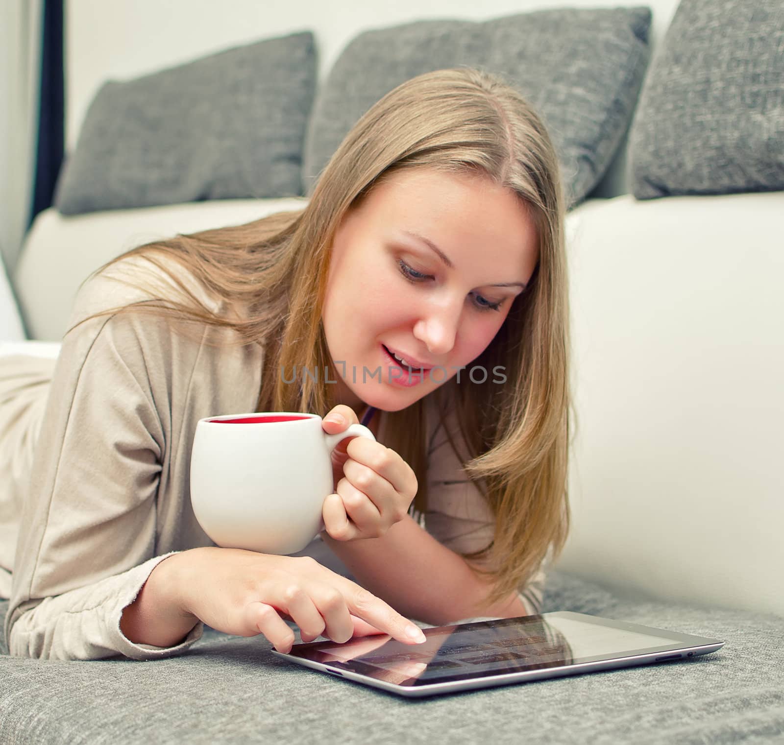 Woman with tablet pc on the sofa.