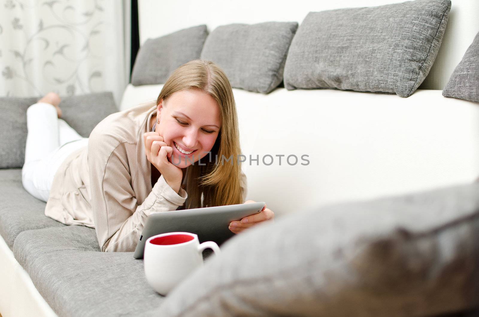 Woman with tablet pc on the sofa.