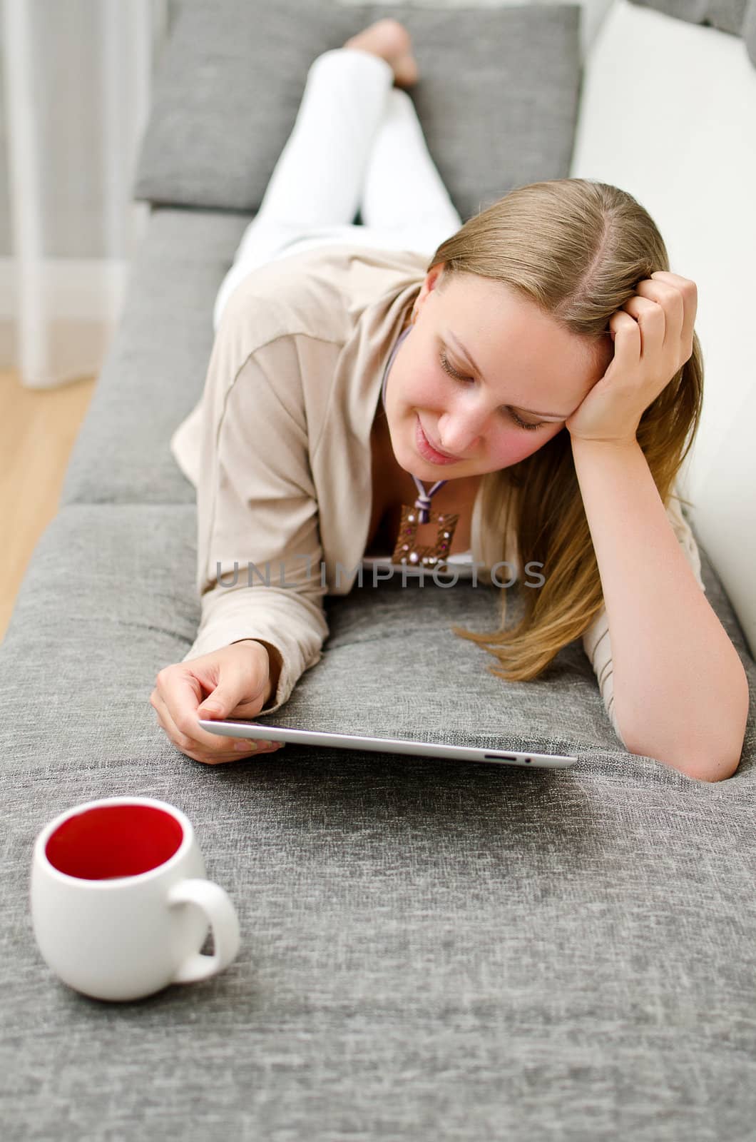 Woman with tablet pc on the sofa.