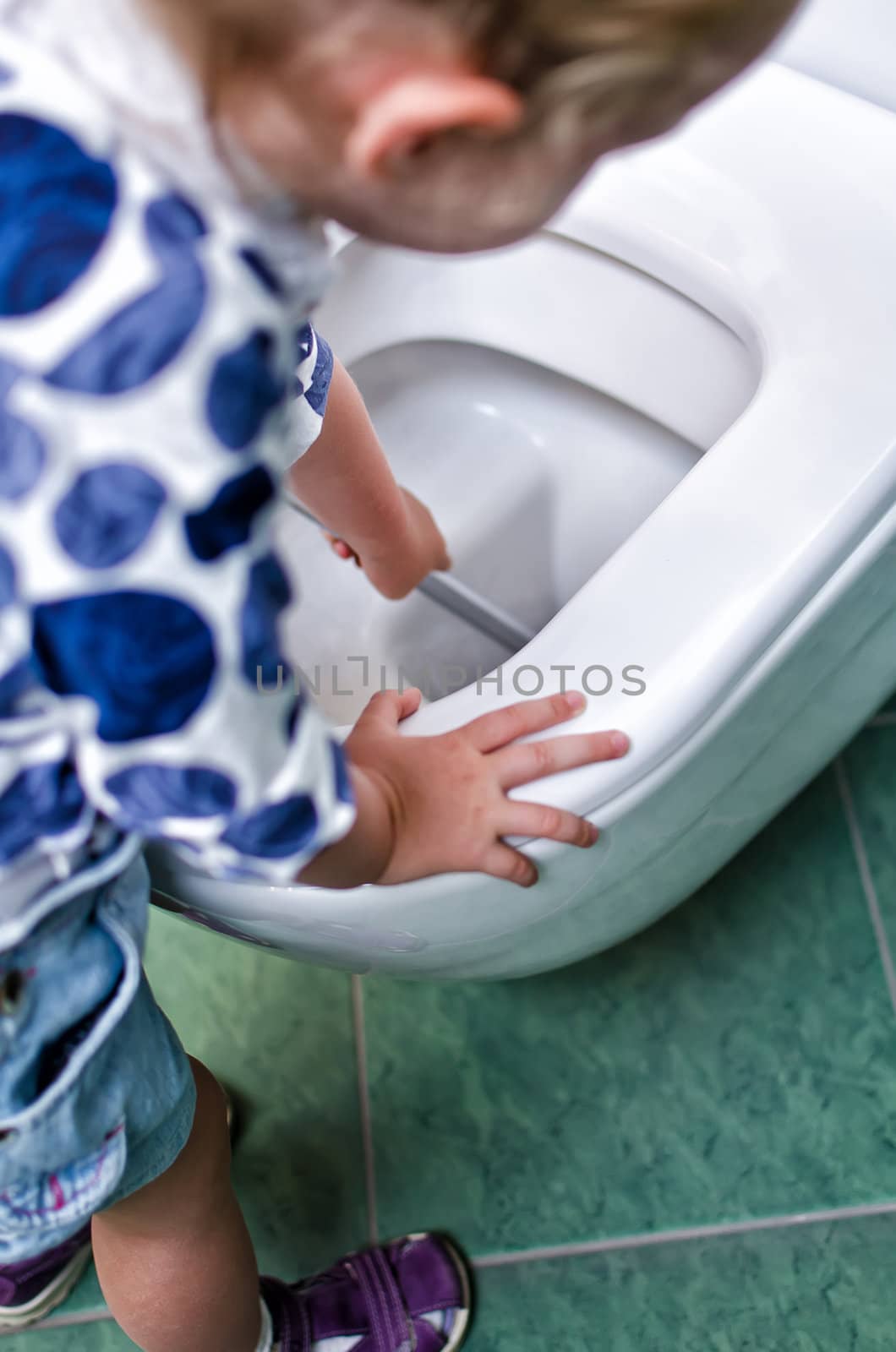 Child labor. Little girl cleans a toilet.