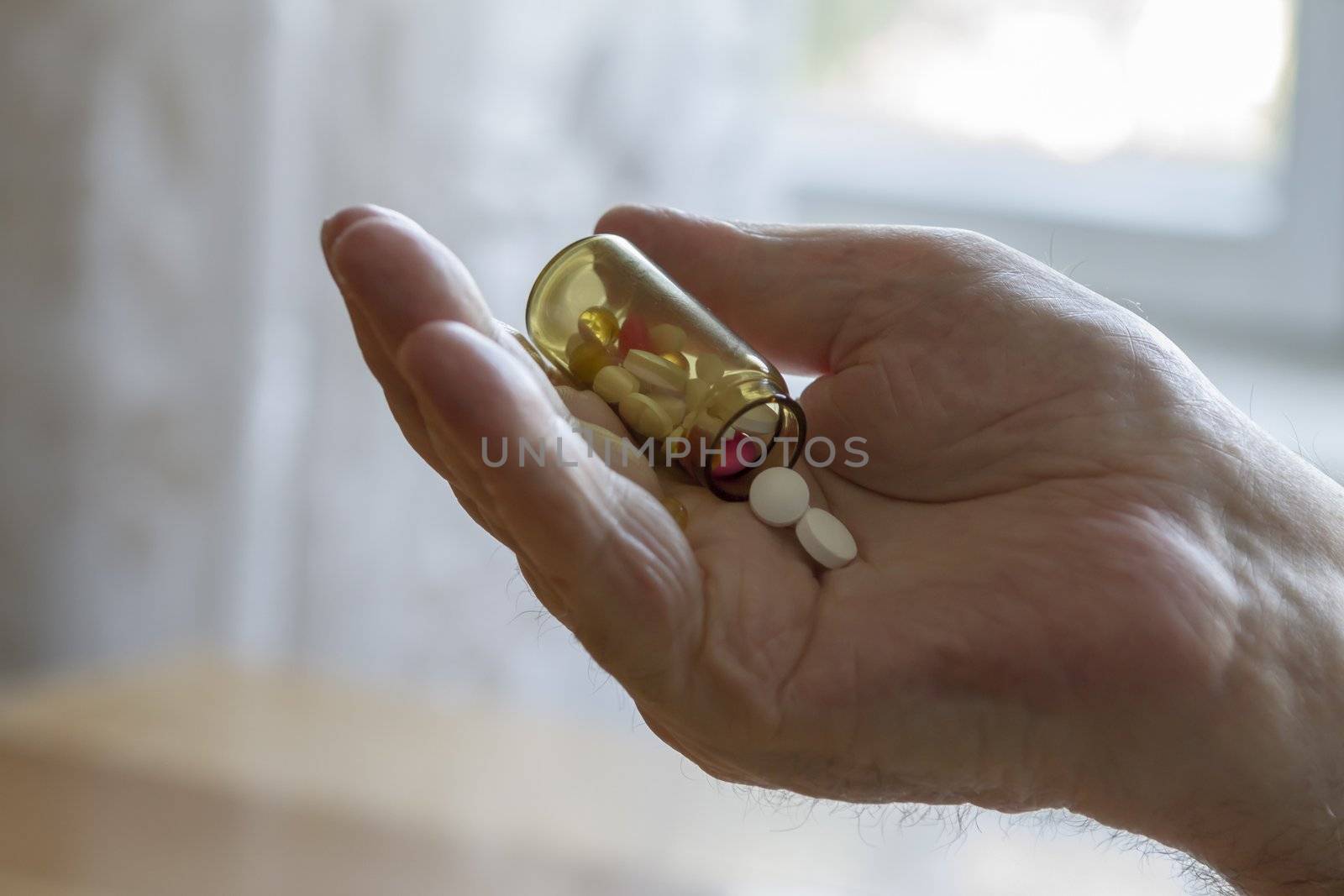 old man holding pills and he needs help