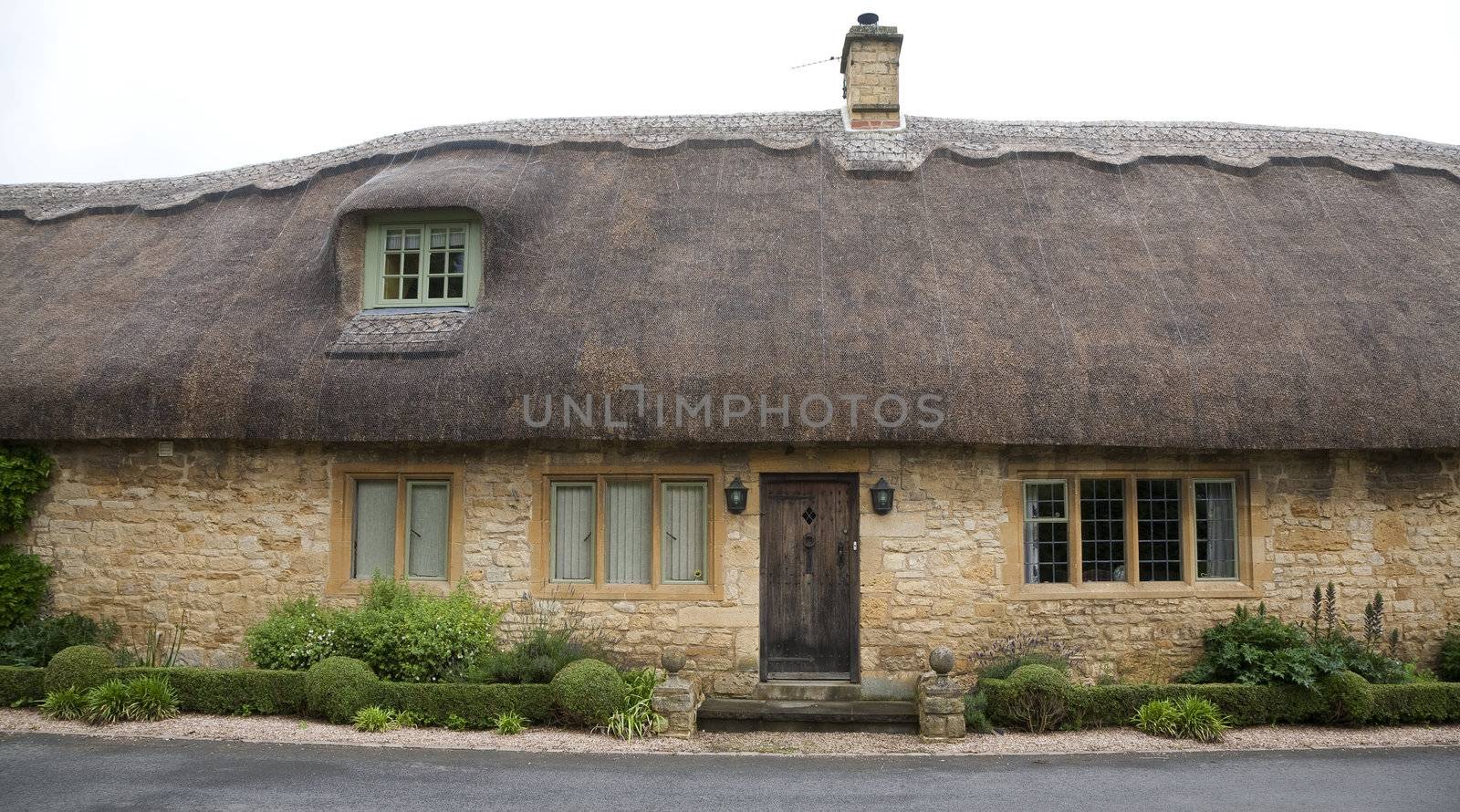 Panorama of beautiful old cottage with thatched roof in in the Cotswold area, United Kingdom.