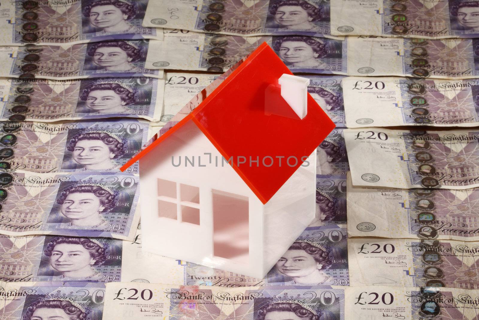 Model of house over twenty pounds bills . Real estate concept 