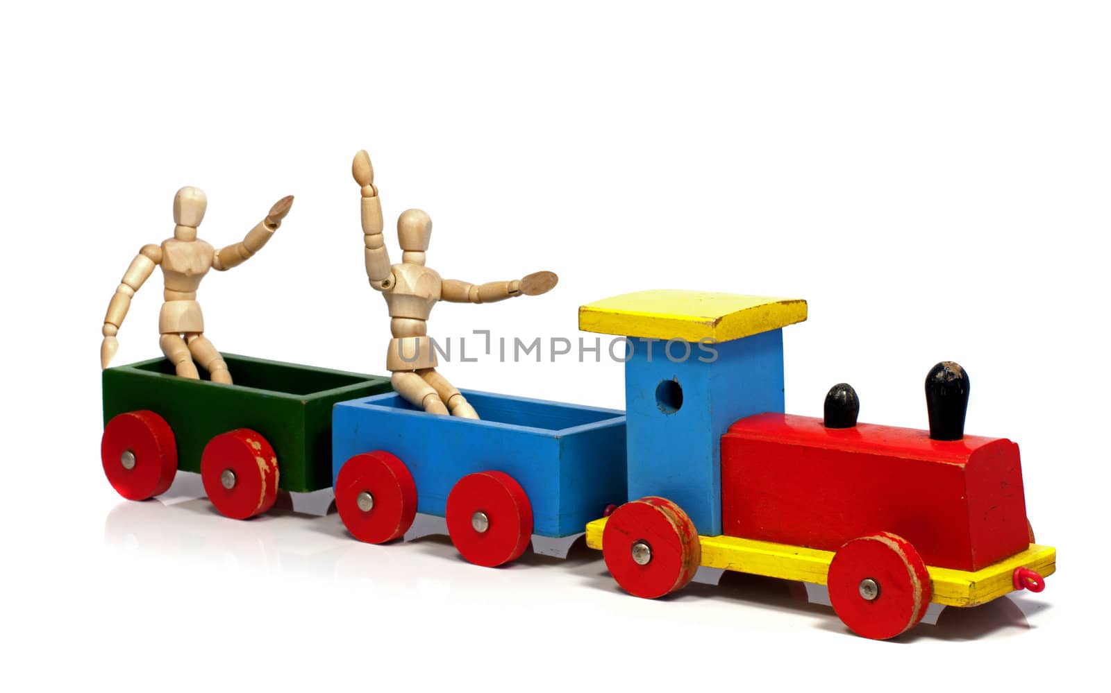 two wooden dolls sitting on a red yellow and green train