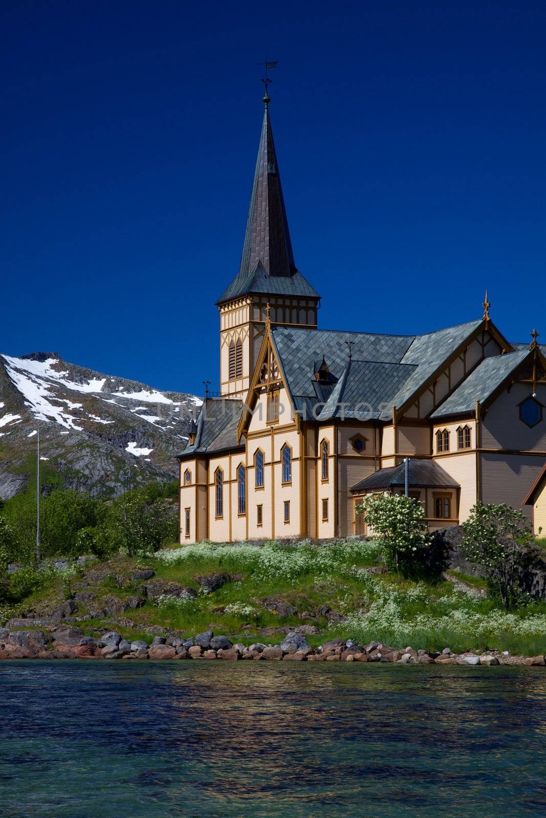 Picturesque Lofoten cathedral on Lofoten islands in Norway with snowy peaks in the background