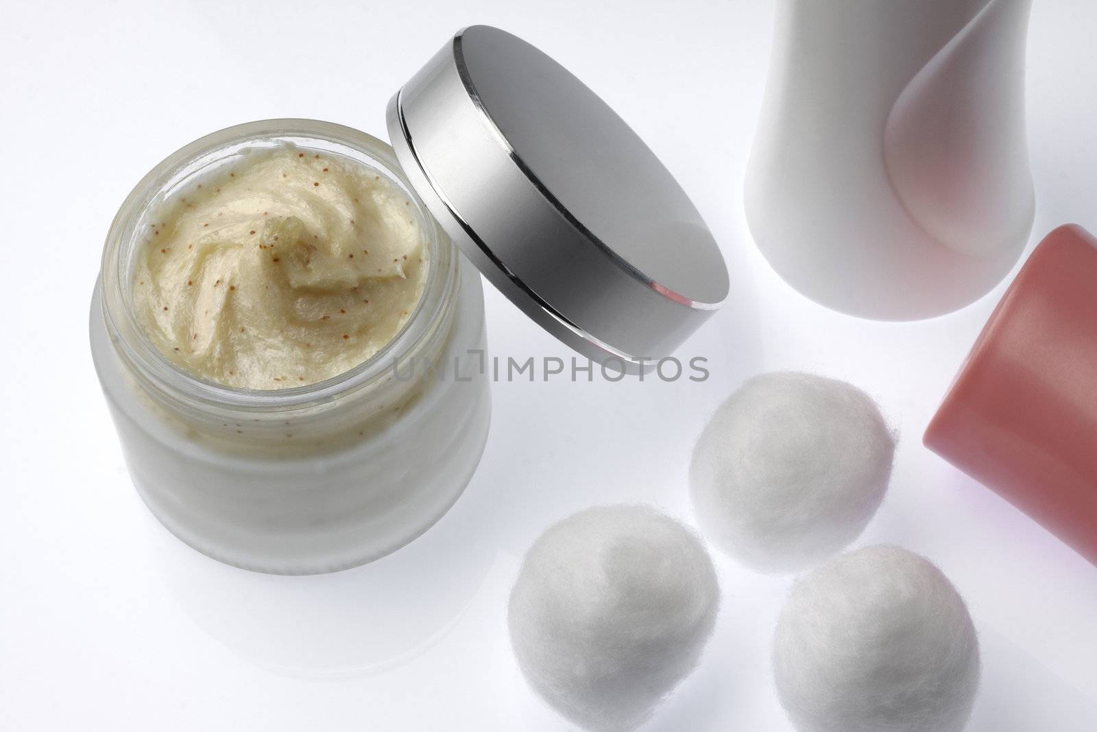 body scrub in packaging with cotton on white background