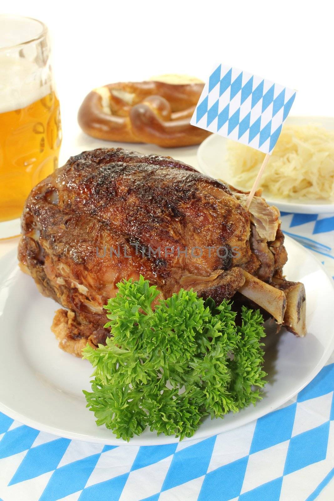 Bavarian roasted pork knuckle and pretzels, beer with sauerkraut on a bright background