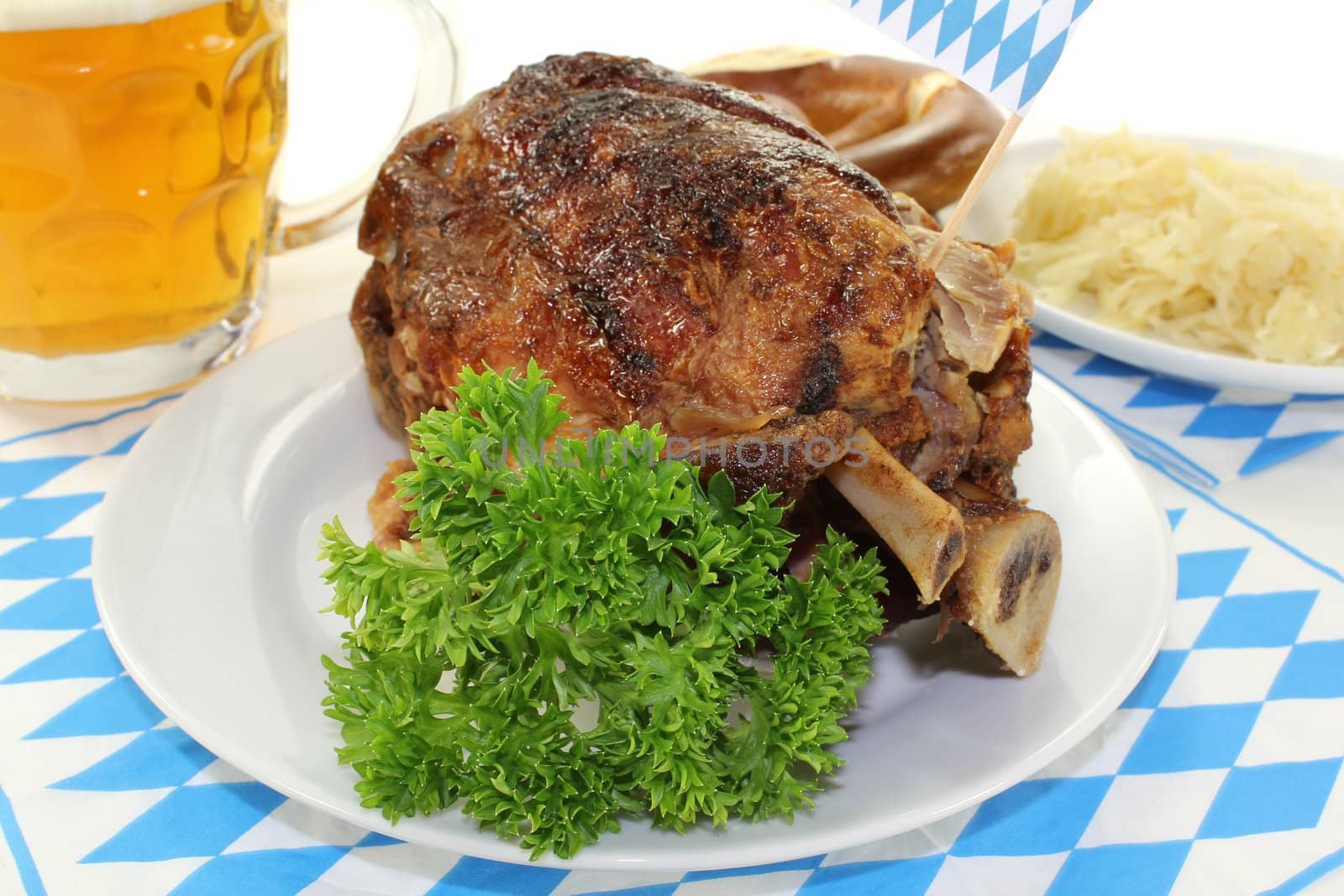 fresh Bavarian roasted pork knuckle and pretzels, beer with sauerkraut on a light background